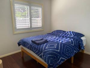 a bed in a room with a blue comforter and a window at Great choice*3 Bedrooms in Fairfield