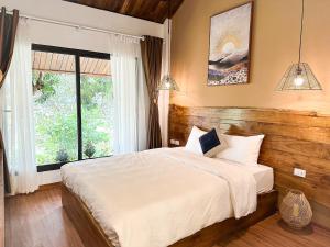 sypialnia z dużym łóżkiem i oknem w obiekcie Vayang Retreat and Camping w mieście Hòa Bình