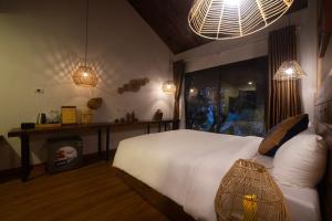 sypialnia z dużym białym łóżkiem i 2 światłami w obiekcie Vayang Retreat and Camping w mieście Hòa Bình