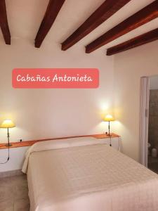 a bedroom with a bed and a sign on the wall at Cabañas Antonieta in Salta