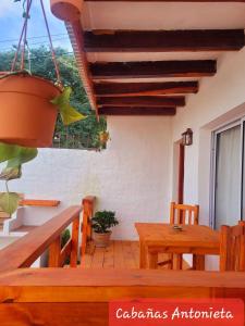 a porch with a wooden table and a potted plant at Cabañas Antonieta in Salta