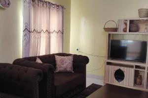 sala de estar con sofá y TV en Cheerful 3 bedrooms HOME with an inbuilt hottub, en Lake View Estate