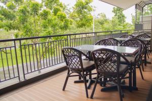 eine Reihe von Tischen und Stühlen auf einem Balkon in der Unterkunft Kana Citra Guesthouse in Surabaya