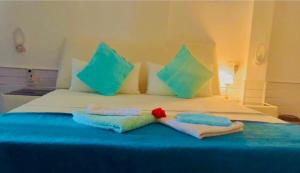 a bed with two pillows and two towels on it at Villa The Leaf in Weligama