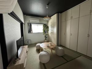 una habitación con una mesa y algunos armarios blancos en 岡田ビル5階, en Tokio