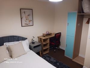 um quarto com uma cama, uma secretária e uma cadeira em POTTERS LOGDE LIVERPOOL by Edl Ventures Ltd em Liverpool