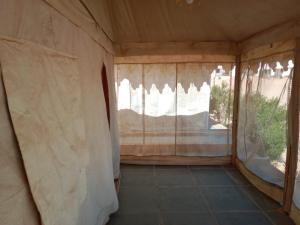 an empty room with curtains and a window at THE THAR DESERT CAMP SAM JAISLMER in Sām