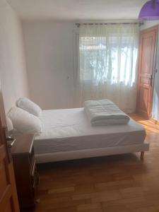 een bed in een kamer met een raam en een nachtkastje bij Low villa in a quiet area - Close to the sea in Villeneuve-Loubet