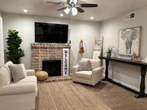 Una sala de estar con dos sillas y una chimenea. en HC Accessible 4 Bed 3 Bath with Sparkling Pool and Spa-we have lifts and roll in shower, en Santee