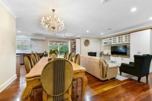 a dining room and living room with a table and chairs at Roselawn Manor - 5 Bedroom Entertainer in Orange
