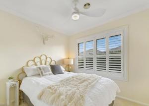 a white bedroom with a large bed and a window at Roselawn Manor - 5 Bedroom Entertainer in Orange