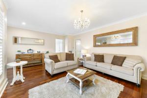a living room with two couches and a table at Roselawn Manor - 5 Bedroom Entertainer in Orange +8 photos