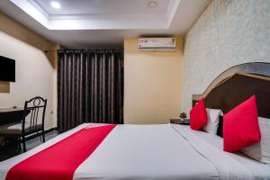 a bedroom with a large bed with red pillows at Grand Aarvi inn in Hyderabad