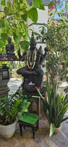 a statue of a woman sitting on a chair in a garden at Villa The Leaf in Weligama