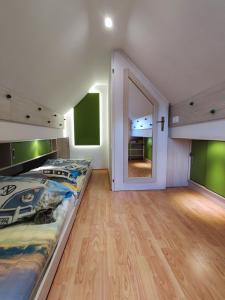 - une chambre avec un grand lit et un grand miroir dans l'établissement Zidanica-Vineyard Cottage Jakše, à Semič