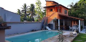a house with a swimming pool in front of a house at Ponta Negra Hospedagem in Maricá +15 photos