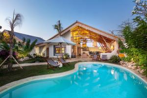 a swimming pool in front of a house at The Bingin Beach Villas' Private Villas in Uluwatu