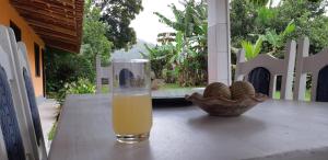 a glass of orange juice sitting on a table with a bowl of peanuts at Ponta Negra Hospedagem in Maricá