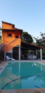 a swimming pool in front of a house at Ponta Negra Hospedagem in Maricá