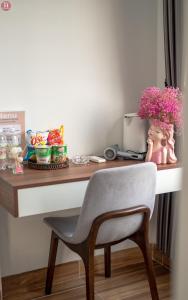 a desk with a chair and a vase of flowers at Tân Hoà Homestay in Da Nang