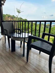 een tafel en stoelen op een balkon met uitzicht bij So View Phuket Resort in Ban Sam Kong