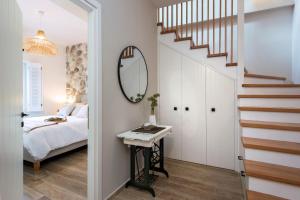 a bedroom with a bed and a mirror and a staircase at Bay View House in Corfu