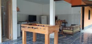 a wooden table in a room with a kitchen at Ponta Negra Hospedagem in Maricá