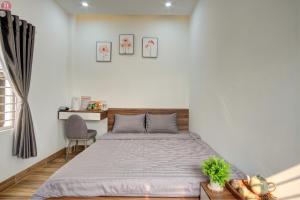 1 dormitorio con 1 cama y 1 silla en Tân Hoà Homestay, en Da Nang