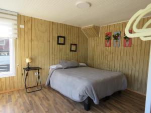een slaapkamer met een bed in een houten muur bij Loft playa blanca ruta160 in Coronel