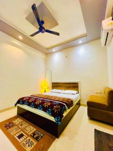 a bedroom with a bed and a ceiling fan at Hotel NK guesthouse in Sikandra