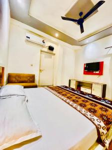 a bedroom with a bed and a ceiling fan at Hotel NK guesthouse in Sikandra