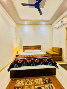 a bedroom with a bed and a ceiling fan at Hotel NK guesthouse in Sikandra