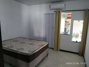 a bedroom with a bed and a window and a door at Casa 345 Mucuri-ba in Mucuri +15 photos