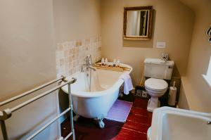 a bathroom with a tub and a toilet at Stour Valley Cottage in Wimborne Minster
