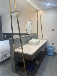 baño con lavabo, espejo y cama en Clover Home Quảng Bình, en Dong Hoi