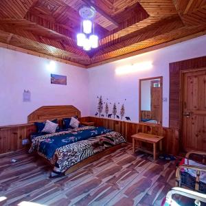 um quarto com uma cama e um tecto de madeira em Alpine Homestay at Gadagusain em Banjār