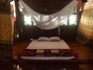 Cama en habitación con mosquitera en Vu Linh Homestay, en Vũ Linh