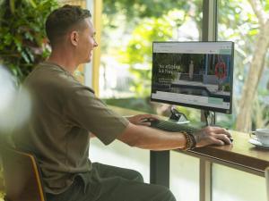 a man sitting at a desk with a computer at Explorar Koh Phangan - Adults Only Resort and Spa in Haad Rin