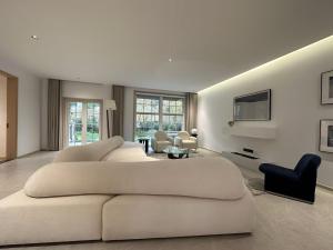 uma ampla sala de estar branca com um grande sofá branco em Stanford Garden em Xangai