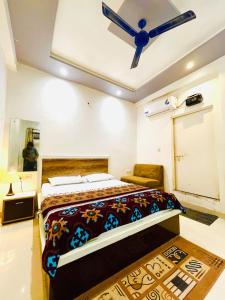 a bedroom with a bed and a ceiling fan at Hotel NK guesthouse in Sikandra