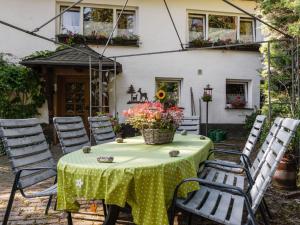 una mesa con un mantel verde y sillas en Cosy apartment in Menkhausen near the ski area, en Schmallenberg