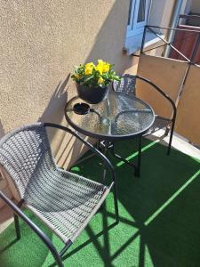 een tafel en stoelen met een potplant op een balkon bij Apartament Jagiełły 14 in Giżycko
