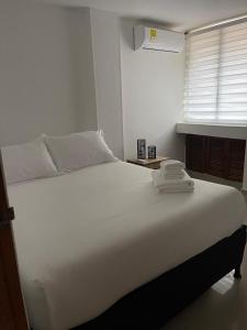 een groot wit bed in een kamer met een raam bij LILI in Cartagena