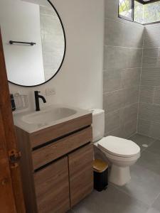 een badkamer met een toilet, een wastafel en een spiegel bij LILI in Cartagena