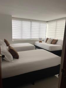 een kamer met drie bedden in een kamer bij LILI in Cartagena
