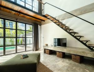 Una sala de estar con un sofá y un televisor. en Berawa Loft 10 by Betterplace, en Canggu