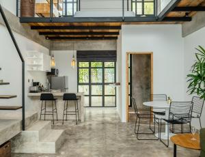 Una cocina y una sala de estar con mesa y sillas. en Berawa Loft 10 by Betterplace, en Canggu