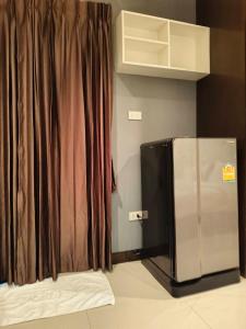- un réfrigérateur en acier inoxydable dans une chambre avec rideau dans l'établissement Jt Place Buriram, à Buriram