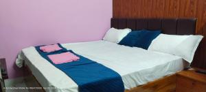 a bed with pink and blue sheets and pillows at HOTEL AYODHYA PAYING GUEST in Ayodhya
