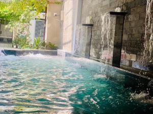 a swimming pool with a water fountain at Cleopatra villa in Thôn Dương Xuân Hạ